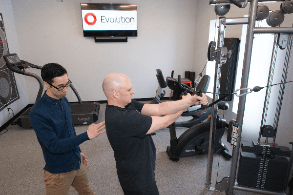 a gym setting with a man and a woman working out together