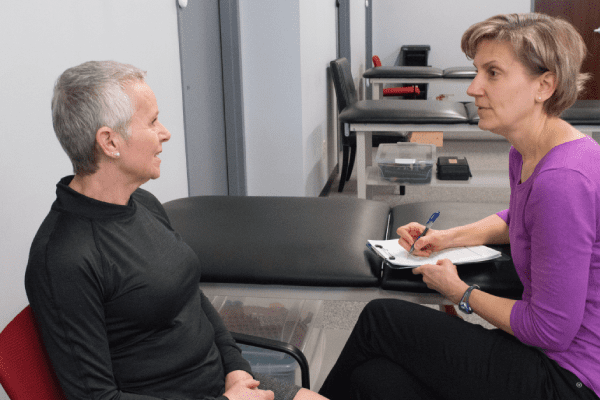 two women sitting in a room, engaged in a conversation